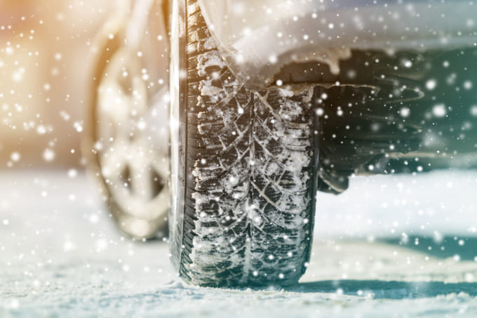 Close-up of car wheels rubber tires in deep winter snow. Transportation and safety concept.