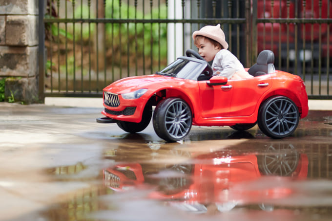 Small baby girl driving toy car
