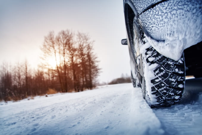 Car tires on winter road covered with snow