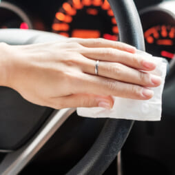 woman hand cleaning on steering wheel in his car, against Novel