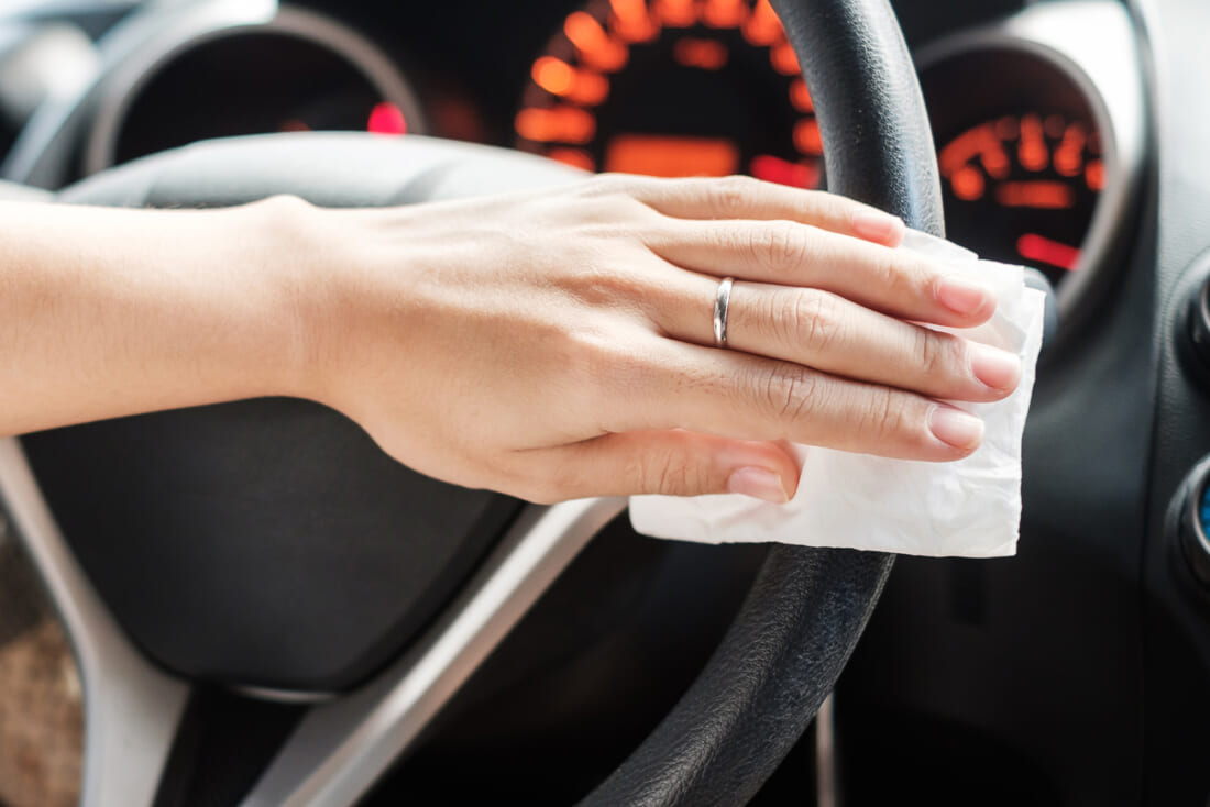 woman hand cleaning on steering wheel in his car, against Novel