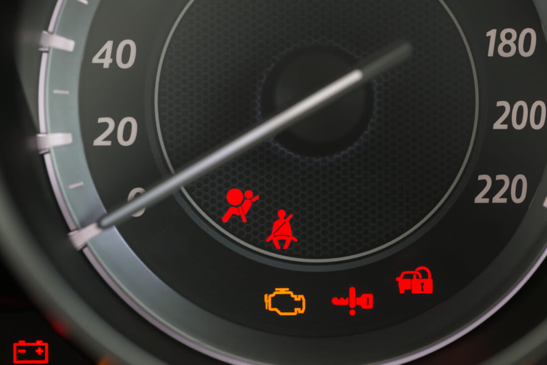 Car Dashboard showing the seat belt warning light