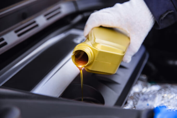 pouring engine oil into a car engine