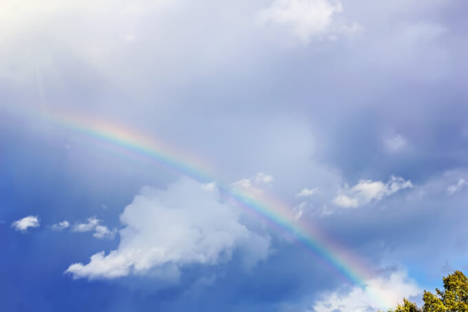 Rainbow in clouds and blue sky